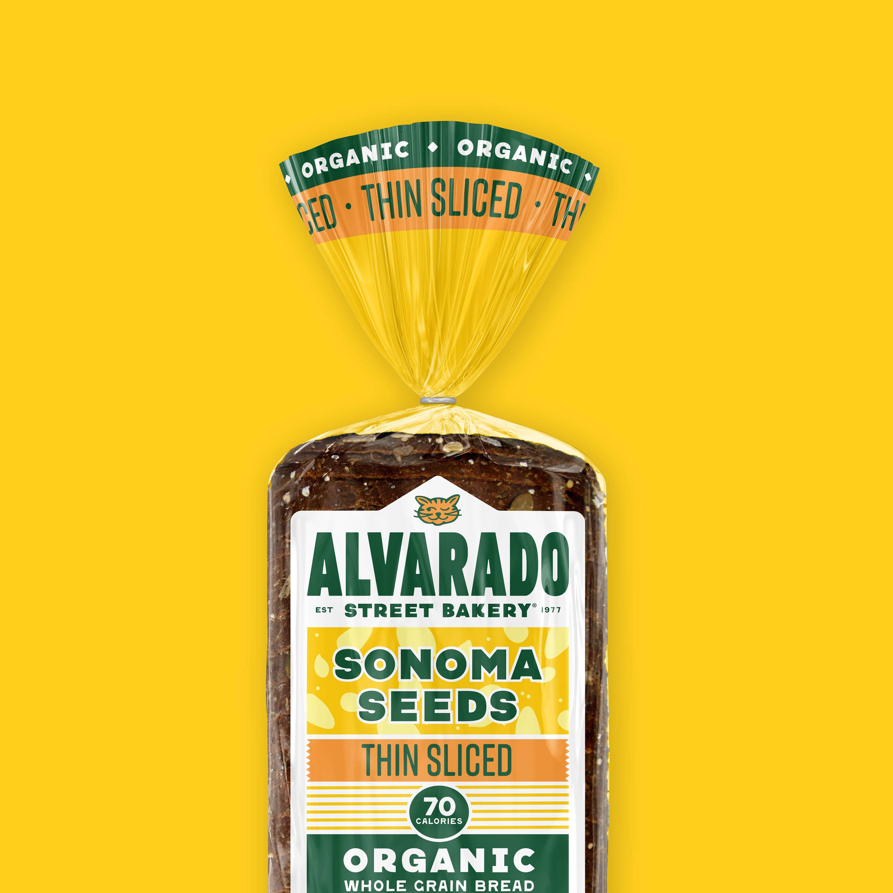 Packaged Sonoma Seeds thin sliced bread with Alvarado Street Bakery label on a yellow background