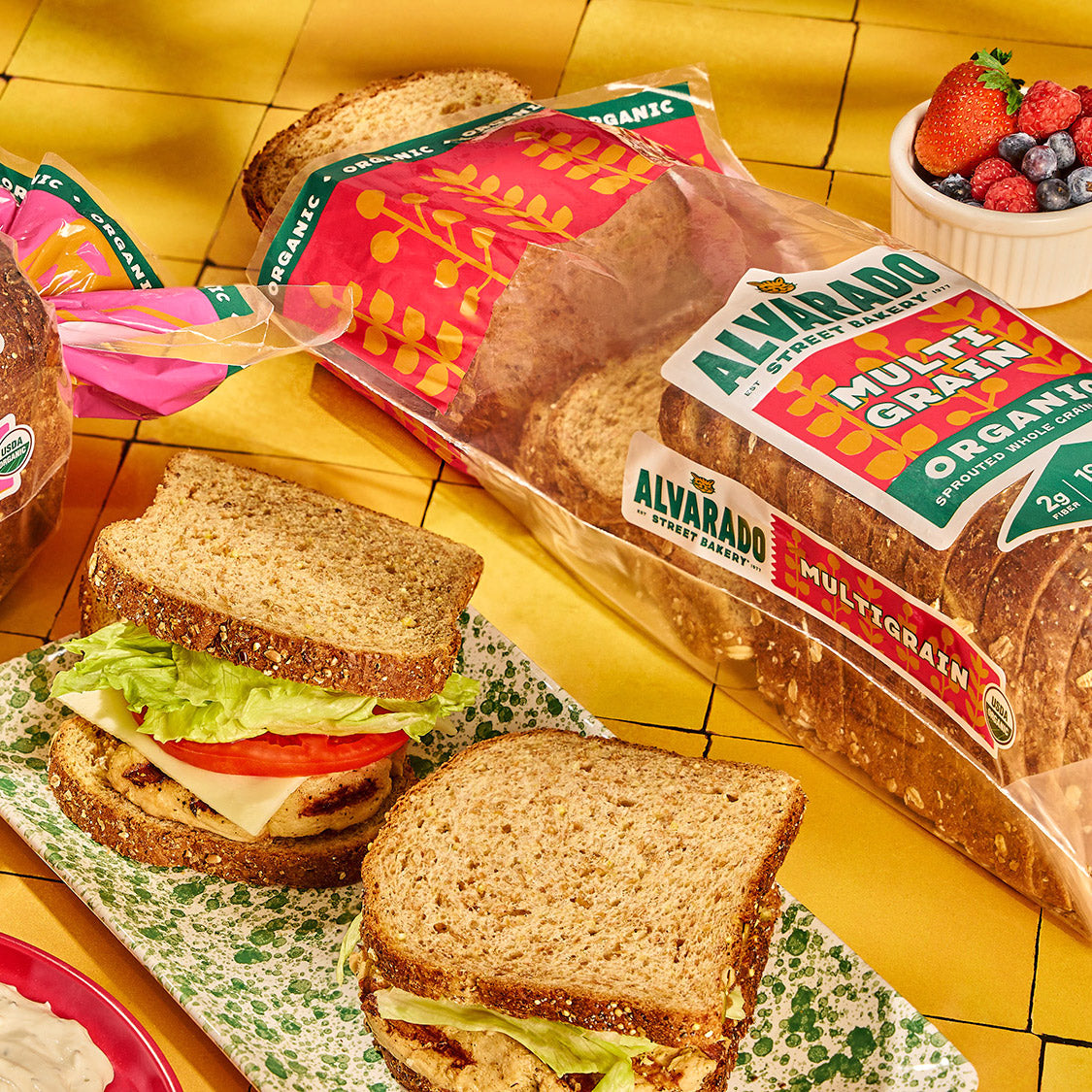 Alvarado Street Bakery multigrain bread with a sandwich on a yellow tiled background